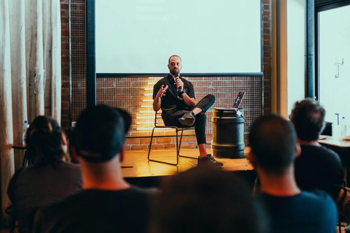 Speaker engages an audience during a business seminar in a modern conference room.
