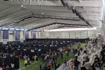 Friends having a fun picnic in the park with a Shih Tzu, enjoying a sunny day outdoors.